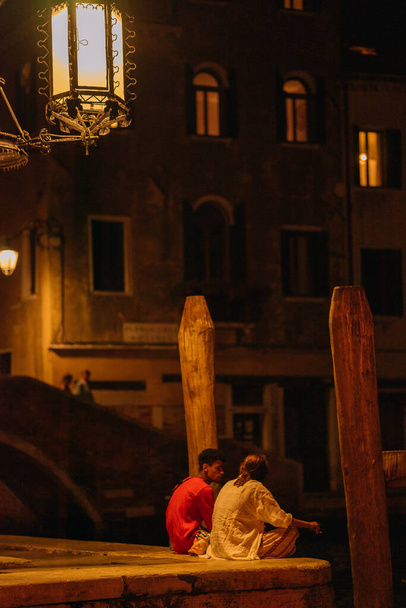 Venedik, İtalya - 13 Ağustos 2016: Venedik, İtalya 'daki akşam ışıklarında insanlar Büyük Kanal' ın güvertesinde oturuyorlar. - Fotoğraf, Görsel