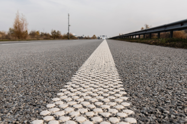 selektivní zaměření pruhu na šedý asfalt na prázdné dálnici  - Fotografie, Obrázek