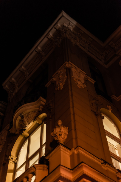 low angle view of old building with lighting in windows - Photo, Image
