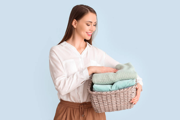 Mladá žena s čistým prádlem na světlém pozadí - Fotografie, Obrázek