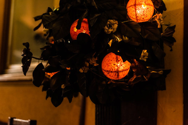 fuoco selettivo di sfere decorative con illuminazione vicino a foglie verdi
  - Foto, immagini
