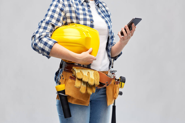 woman or builder with phone and working tools - Foto, immagini