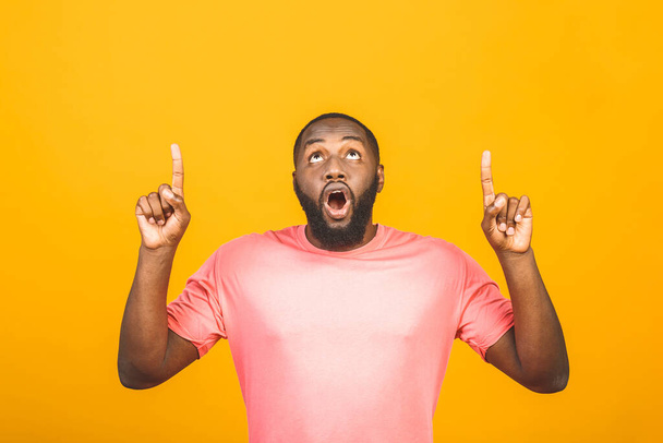 Портрет щасливого молодого афро-американського чоловіка з випадковим посмішкою, вказуючи убік пальцем, дивлячись в камеру з схвильованим виразом обличчя. - Фото, зображення