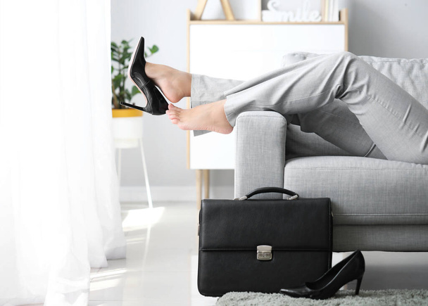 Femme d'affaires se détendre sur le canapé après le travail à la maison
 - Photo, image