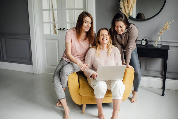 a group of girlfriends communicate with a friend via a video conference on a laptop. Friendship - Fotó, kép