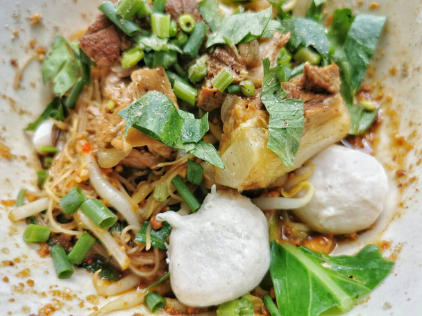Fideos secos, cerdo estofado, albóndigas en un tazón. Comida callejera popular en Tailandia. Fácil de comer
. - Foto, Imagen