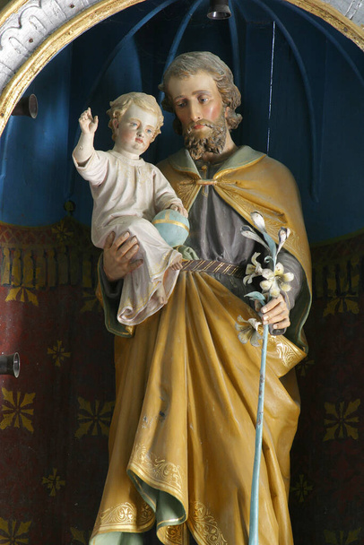 Sint-Jozef houdt het kindje Jezus, standbeeld op het altaar van Sint-Jozef in de parochiekerk van de Heilige Drie-eenheid in Radoboj, Kroatië - Foto, afbeelding