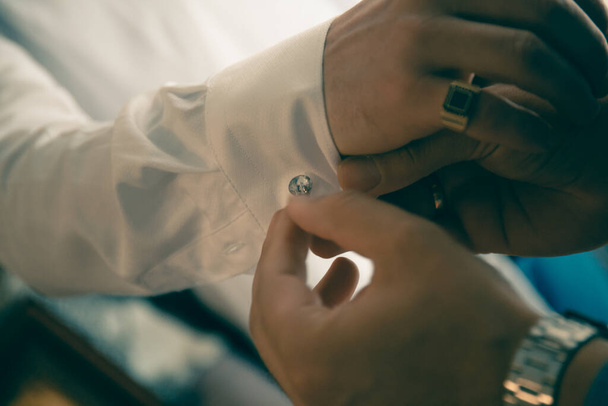 The helps groom to put on cufflinks close up - Фото, зображення