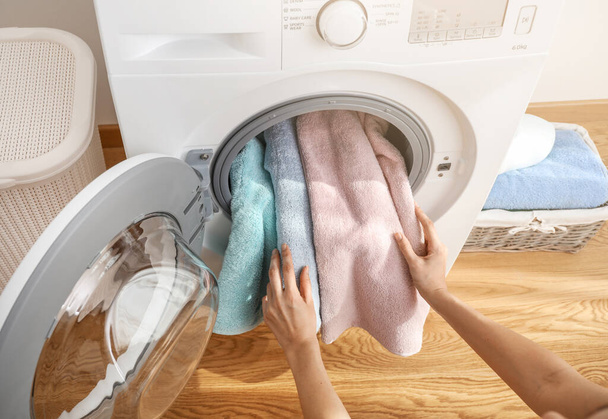 Person loading bath towels in washing machine - Photo, Image