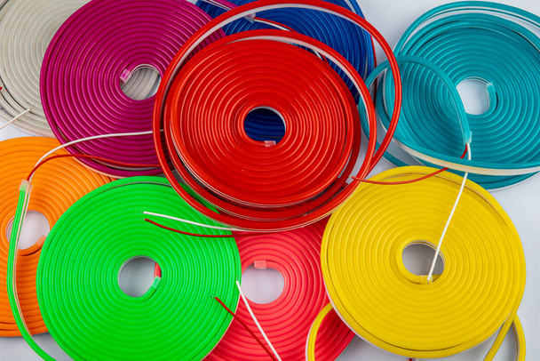 Flexible cinta led neón flex en diferentes colores sobre fondo blanco. Fondo de colores neón de moda
. - Foto, imagen