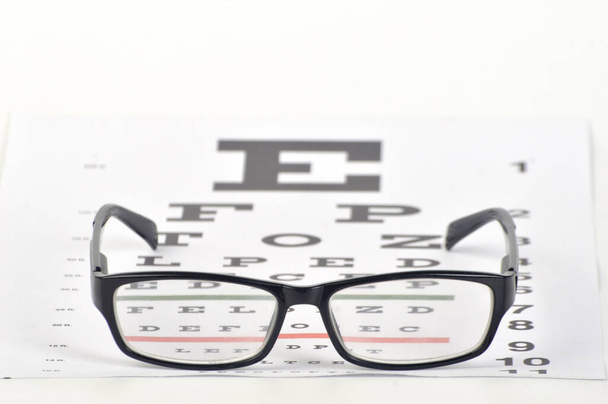 Brille auf Sehtest-Diagramm Hintergrund Nahaufnahme - Foto, Bild