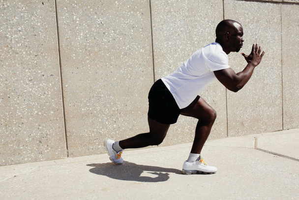 Profil d'un coureur professionnel noir afro-américain prêt à commencer à courir dans la rue
 - Photo, image