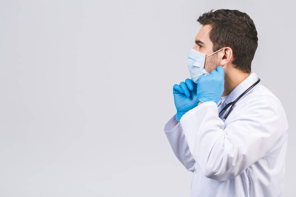 Coronavirus-Konzept. Mann Doktor setzt medizinische Maske isoliert über weißem Hintergrund auf. Covid-19-Grippepandemie.  - Foto, Bild