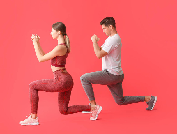 Sporty young couple training on color background - Foto, immagini