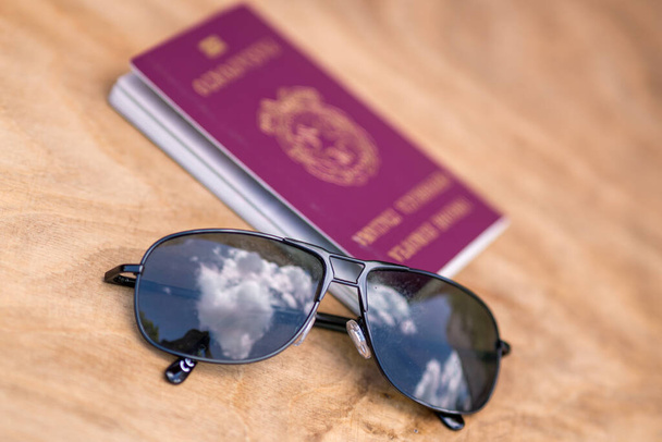 Zomervakantie concept. Zonnebril en Italiaans paspoort op een zandstrand - Foto, afbeelding