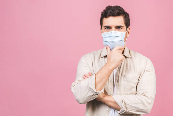 Protección contra enfermedades contagiosas, coronavirus. Hombre con máscara higiénica para prevenir infecciones, enfermedades respiratorias transmitidas por el aire como la gripe, 2019-nCoV. Aislado sobre fondo rosa
. - Foto, imagen