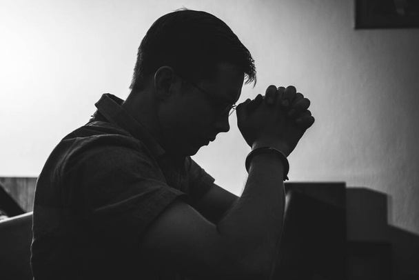 Silhouette dell'uomo che prega in chiesa in monotono
 - Foto, immagini