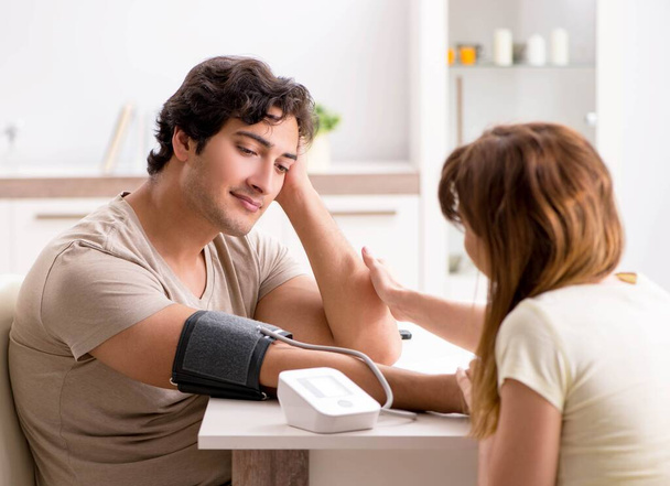 Ehefrau überprüft Blutdruck ihrer Ehemänner - Foto, Bild