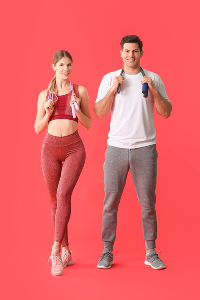Sporty young couple on color background - Фото, зображення