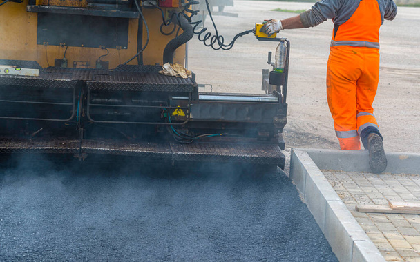 Asfalt bestrating met asfalt verwarmd tot temperaturen boven 160 graden tijdens de weg in de bouw - Foto, afbeelding