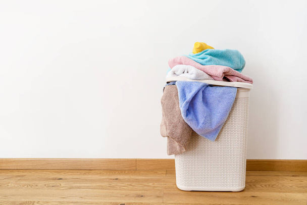 Cesta de lavanderia com toalhas sujas no fundo branco
 - Foto, Imagem