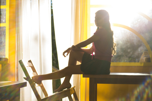 young girl sitting on the table - Foto, afbeelding