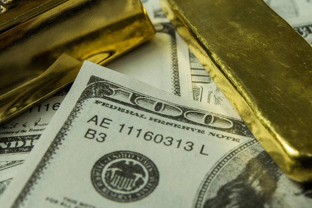 Close-up afbeelding van dollarbiljet met goudstaaf - Foto, afbeelding