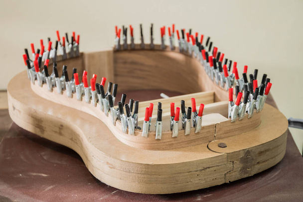 Kytara v procesu tvorby s klipy držet dřevo ve tvaru - Fotografie, Obrázek