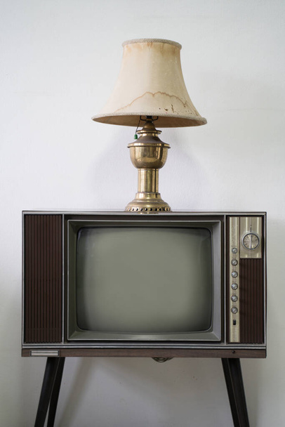 Vintage lamp on top of television in white room - Photo, Image