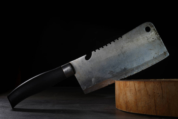 Vieja cuchilla doblada pegada en tablero de corte de carnicero de madera
 - Foto, imagen