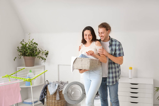 feliz jovem casal fazendo lavanderia em casa - Foto, Imagem