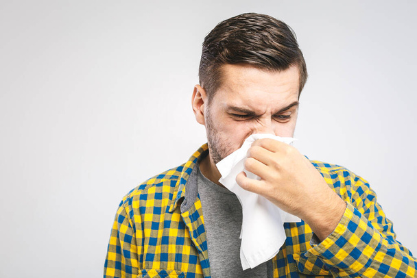 Imagen del estudio con un joven con pañuelo. El enfermo aislado tiene secreción nasal. hombre hace una cura para el resfriado común
 - Foto, imagen