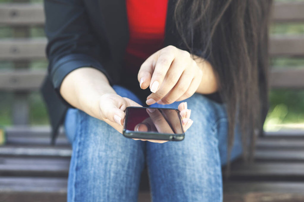 fiatal nő használ okostelefon a parkban - Fotó, kép