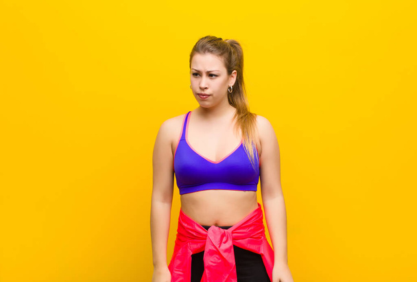 young blonde woman feeling sad, upset or angry and looking to the side with a negative attitude, frowning in disagreement. sport concept - Photo, image