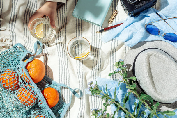 Feminine summer picnic flatlay, fruits, berries and lemon water on striped cotton blanket - Foto, Imagem