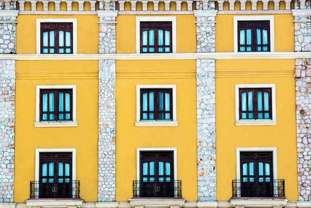 Fotafa de las puertas y ventanas de un hotel amarillo en patron. - Foto, imagen