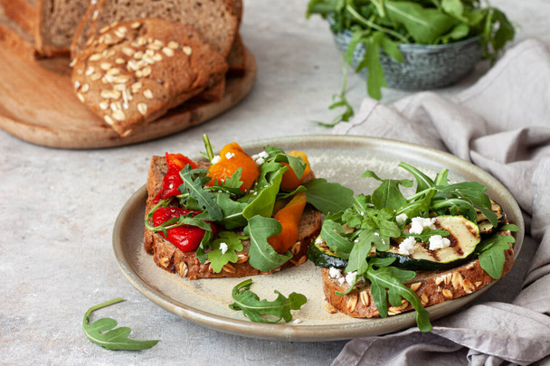 Здоровый сэндвич с рукколой, жареными овощами и фета
 - Фото, изображение