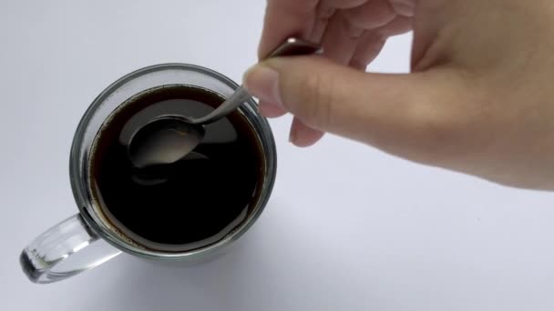 Person hand stirring coffee a cup with spoon. Breakfast morning of a cup coffee - Footage, Video