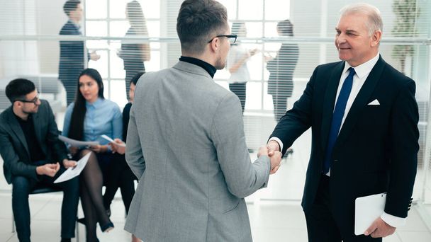 businessmen shake hands standing in the conference room. - 写真・画像
