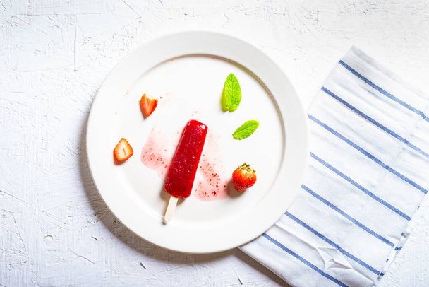 Köstliche Erdbeer-Eis am Stiel auf hellem Hintergrund - Foto, Bild