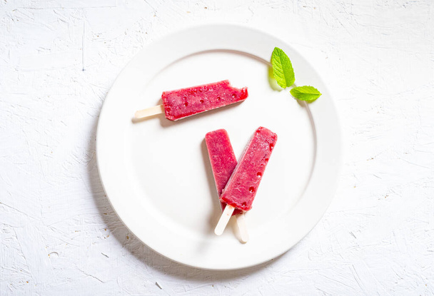 Köstliche Erdbeer-Eis am Stiel auf hellem Hintergrund - Foto, Bild