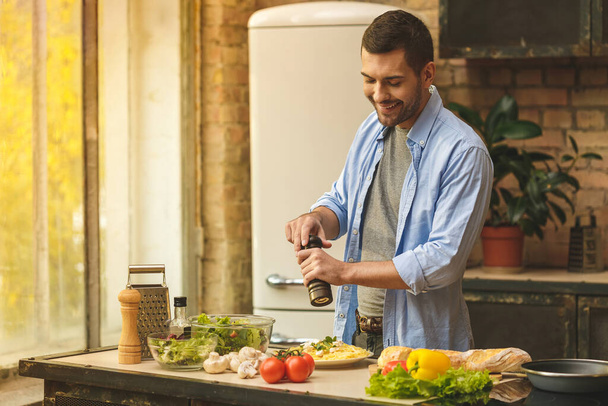 Ο άνθρωπος προετοιμασία νόστιμα και υγιεινά τρόφιμα στην κουζίνα στο σπίτι σε μια ηλιόλουστη μέρα.  - Φωτογραφία, εικόνα