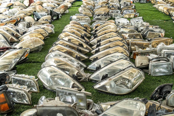 Used headlamp components for sale at scrapyard area - Photo, Image