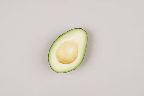 Fresh green avocado on a grey background. - Valokuva, kuva
