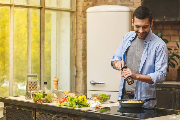Ο άνθρωπος προετοιμασία νόστιμα και υγιεινά τρόφιμα στην κουζίνα στο σπίτι σε μια ηλιόλουστη μέρα.  - Φωτογραφία, εικόνα