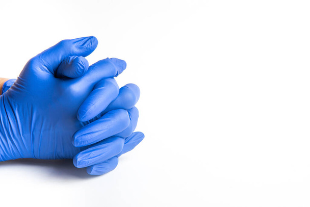 Hände mit blauen Latex-Einmalhandschuhen auf schlichtem weißem Hintergrund. - Foto, Bild
