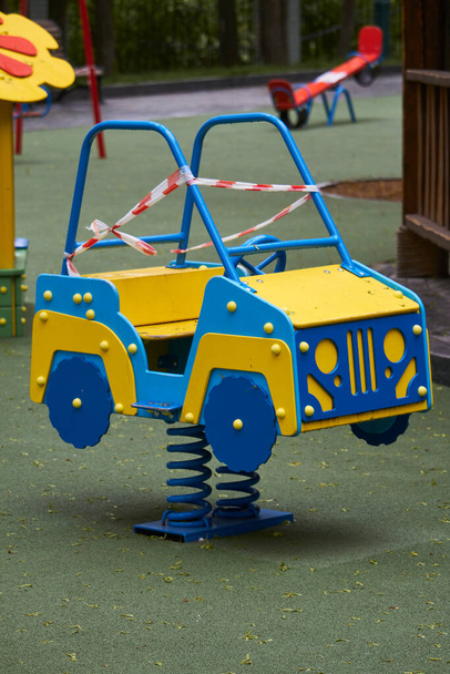 Parque infantil vazio sem crianças com fita vermelha e branca listrada, limitações colocadas em quarentena para o coronavírus Covid19
 - Foto, Imagem