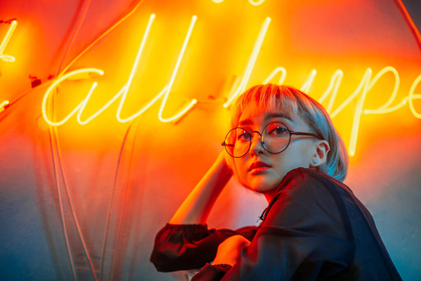 Young adult asian female wearing glasses in front of neon light  - Foto, Bild