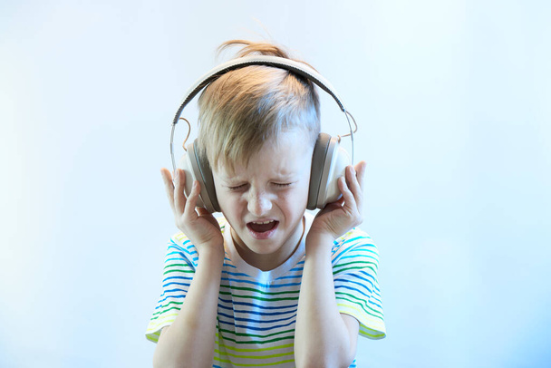 ヘッドフォンの面白い少年は音楽を聞いて歌を歌う - 写真・画像