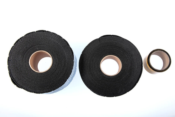 Black industrial tape in roll on white background. Rubber insulating tape. Sound insulation adhesive tape. - Photo, Image